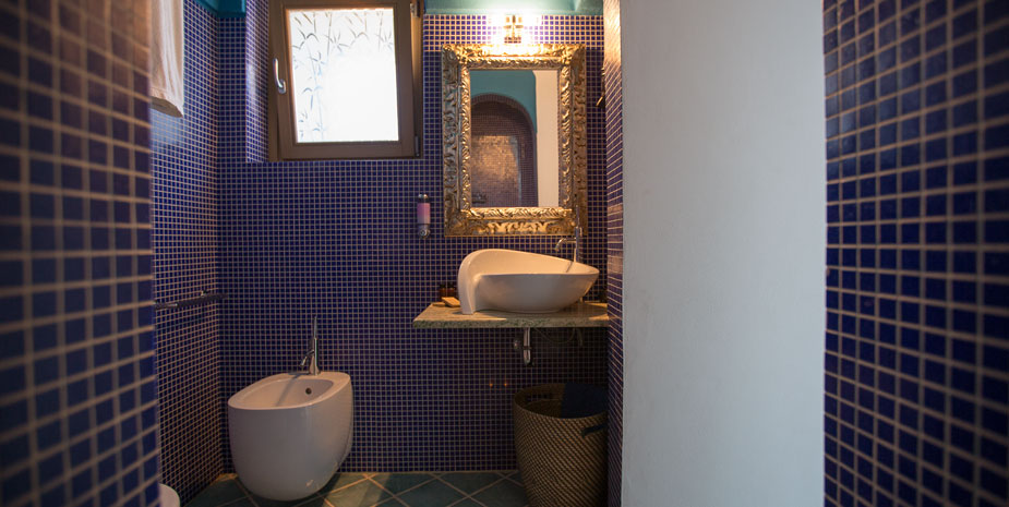 Dammuso Grecale | bagno con doccia pareti in mosaico sanitari di design
